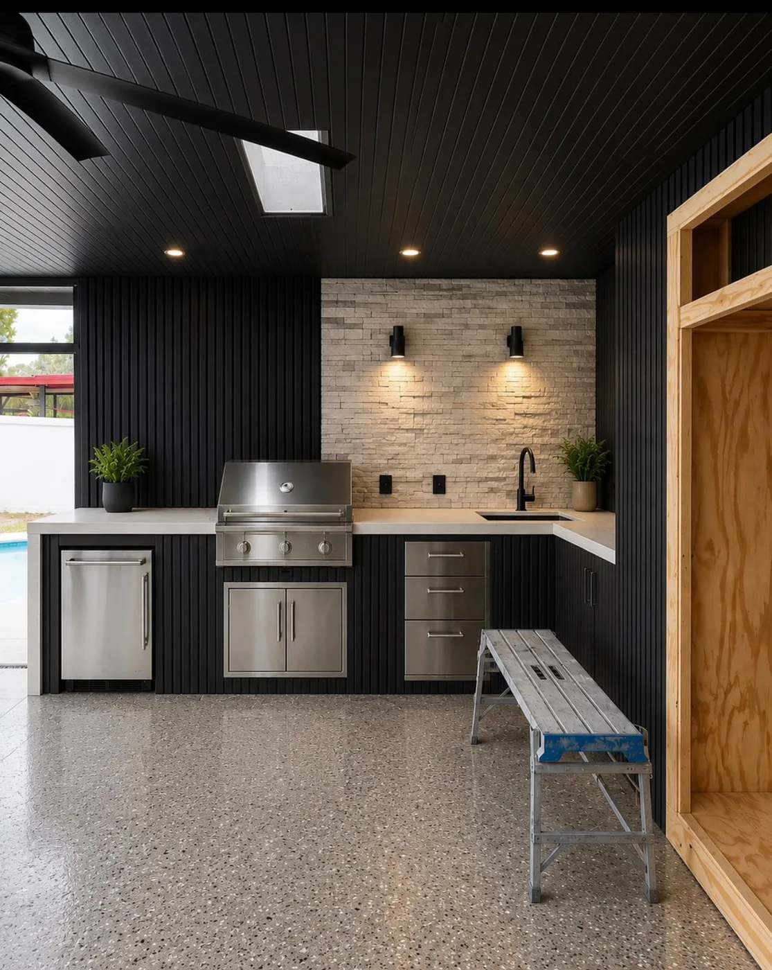 Outdoor kitchen with stone counters and grill wall